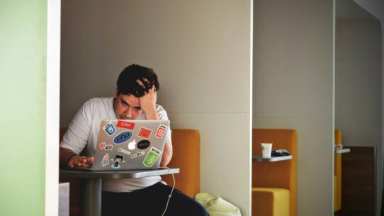 man wearing white top using MacBook