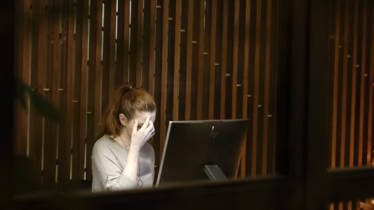 a woman sitting in front of a laptop computer